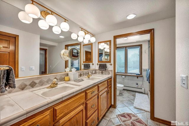 bathroom with vanity, a textured ceiling, a baseboard radiator, toilet, and tile patterned floors