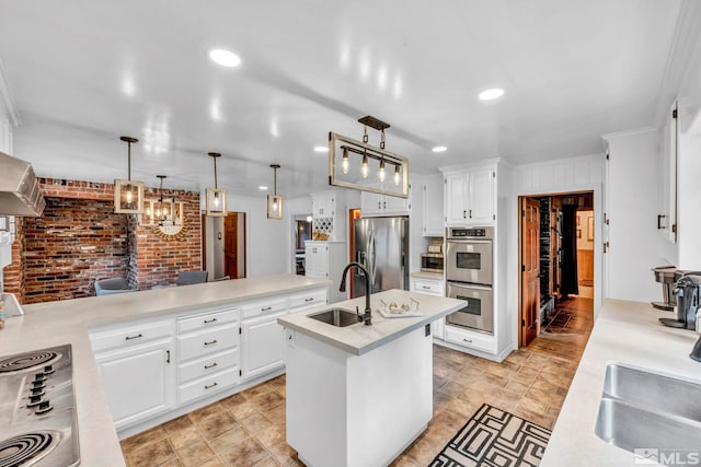 kitchen with an island with sink, sink, decorative light fixtures, white cabinetry, and stainless steel appliances