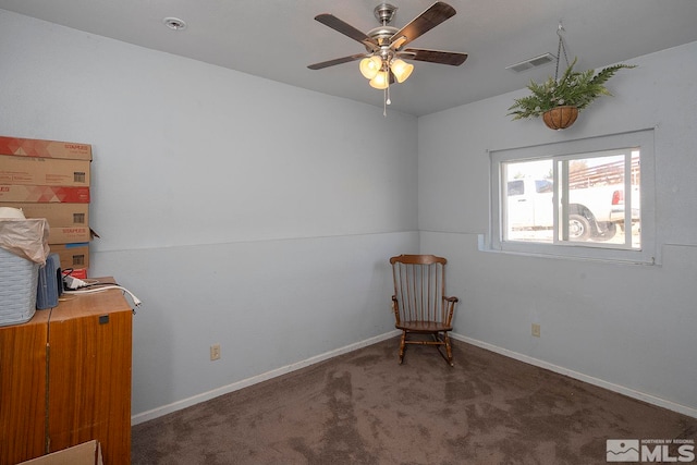 unfurnished room with ceiling fan and dark carpet