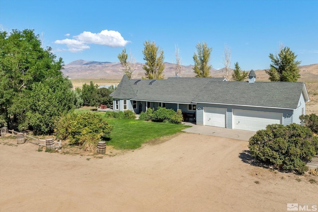 single story home featuring a front yard, a mountain view, and a garage