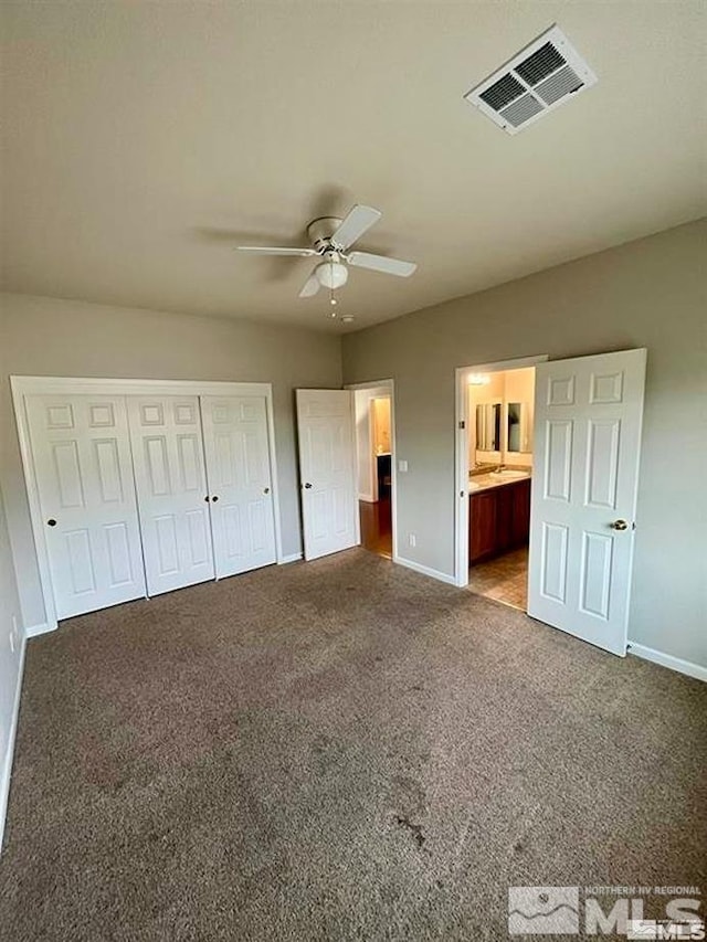 unfurnished bedroom featuring ensuite bath, carpet, and ceiling fan