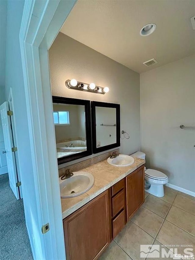 bathroom featuring vanity, toilet, and tile patterned flooring