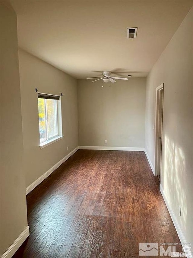 empty room with dark hardwood / wood-style floors and ceiling fan