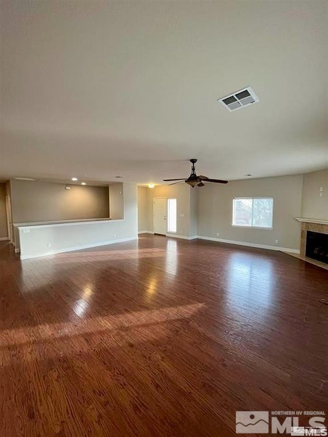 unfurnished living room with ceiling fan, dark hardwood / wood-style flooring, and a fireplace