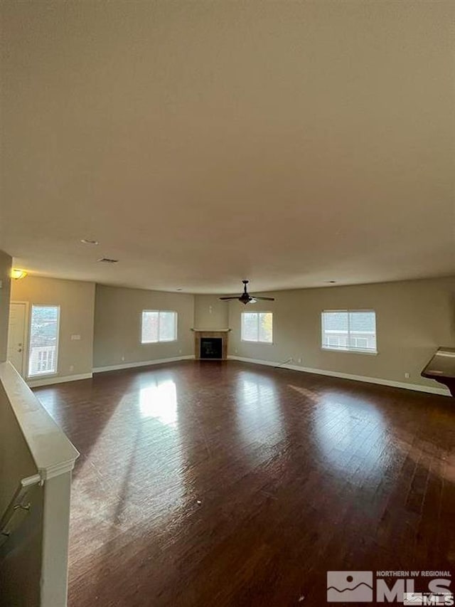 unfurnished living room featuring dark hardwood / wood-style floors and ceiling fan