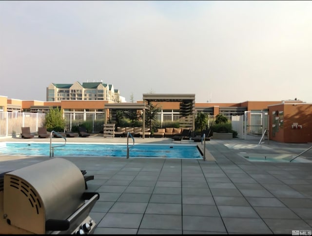 view of swimming pool featuring a patio area and grilling area