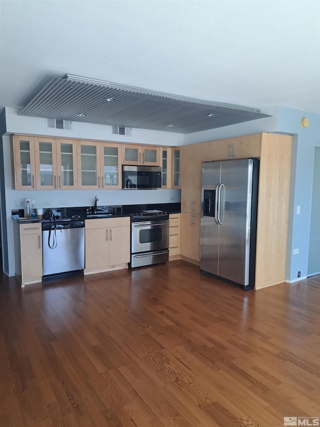 kitchen with sink, stainless steel appliances, and dark wood-type flooring