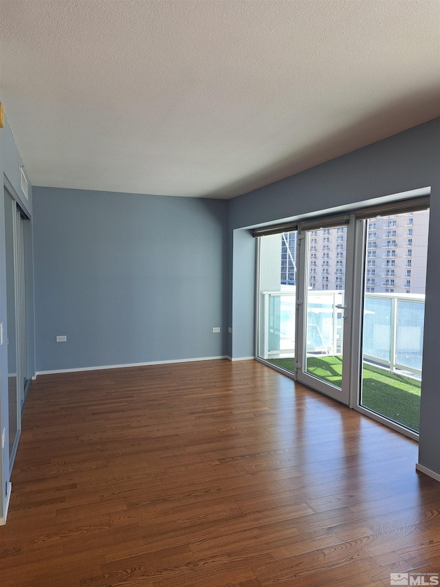 spare room featuring wood finished floors and a textured ceiling