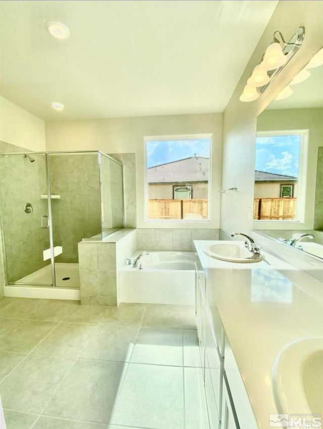 bathroom with independent shower and bath, vanity, plenty of natural light, and tile patterned flooring