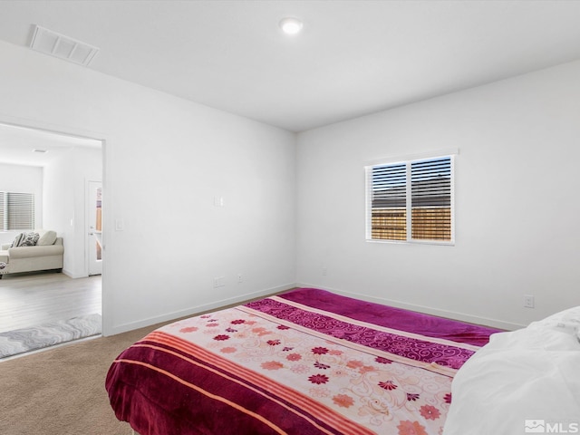 carpeted bedroom featuring visible vents and baseboards