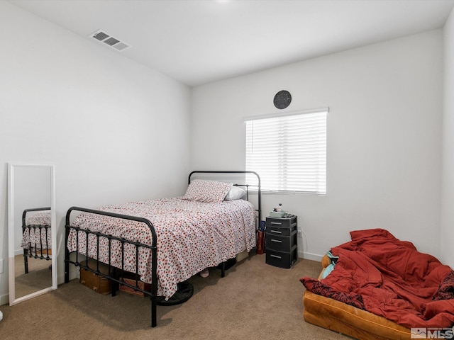 carpeted bedroom featuring baseboards and visible vents