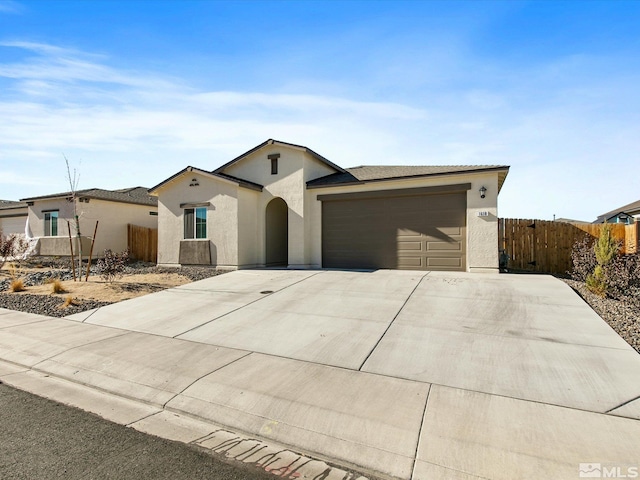 ranch-style home featuring stucco siding, an attached garage, concrete driveway, and fence