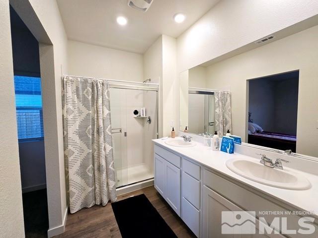 bathroom featuring a shower with door, vanity, and hardwood / wood-style flooring