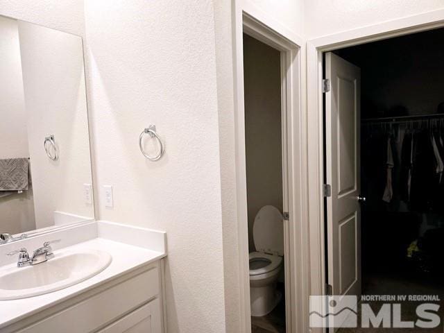 bathroom featuring vanity and toilet