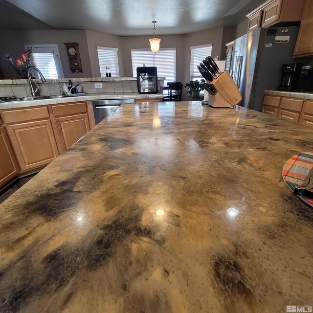 kitchen featuring sink, decorative light fixtures, plenty of natural light, and stainless steel appliances