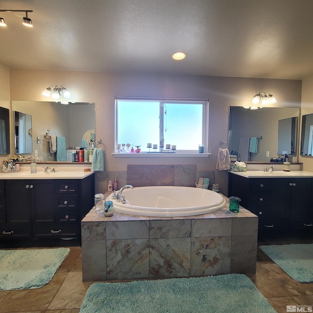 bathroom featuring a relaxing tiled tub and vanity