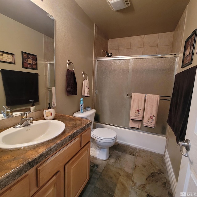 full bathroom featuring vanity, toilet, and combined bath / shower with glass door