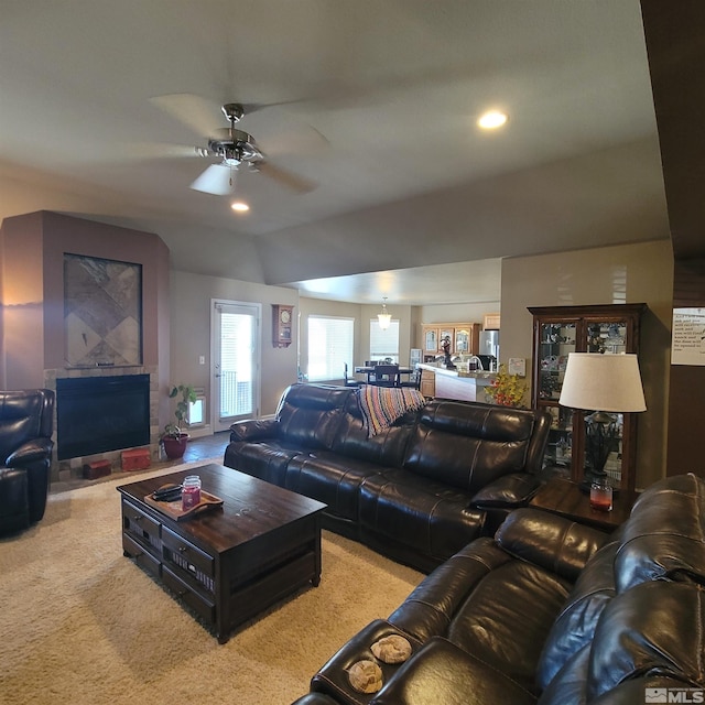 living room featuring ceiling fan, light colored carpet, and vaulted ceiling