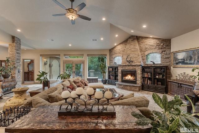 living room with high vaulted ceiling, ceiling fan, and a stone fireplace