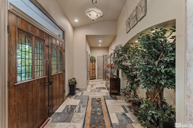 foyer featuring french doors and lofted ceiling