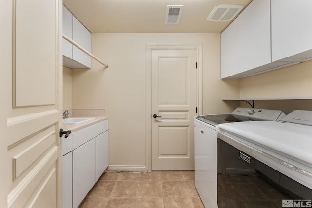 laundry room with light tile patterned floors, cabinets, sink, and washer and dryer