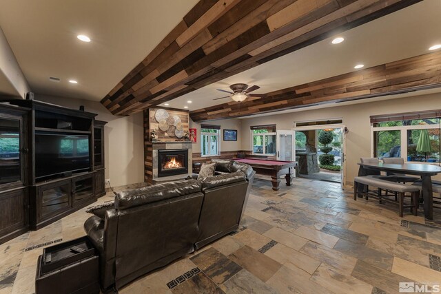 living room with pool table, a fireplace, ceiling fan, and beamed ceiling