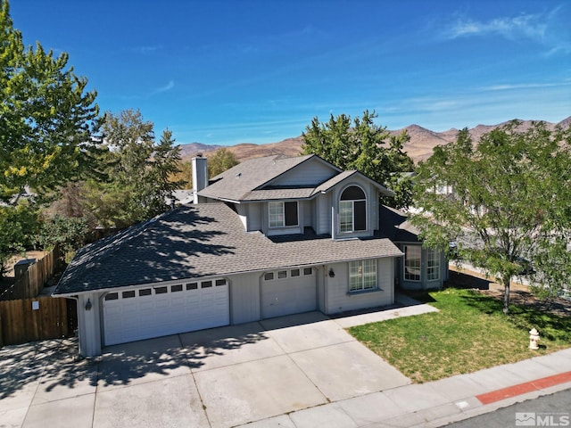 view of property with a front yard, a mountain view, and a garage