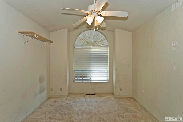 spare room featuring ceiling fan, light colored carpet, a textured ceiling, and vaulted ceiling