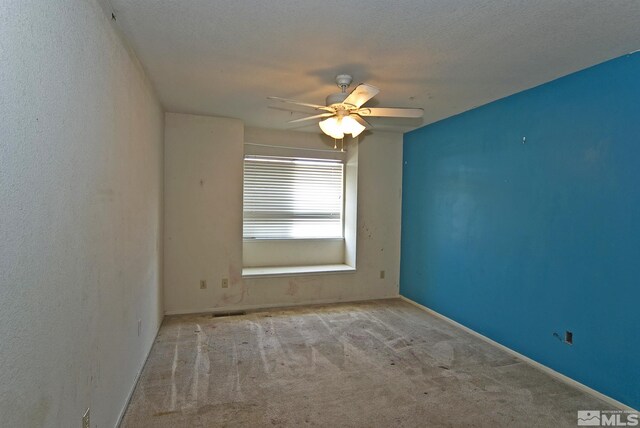 carpeted empty room featuring a textured ceiling and ceiling fan