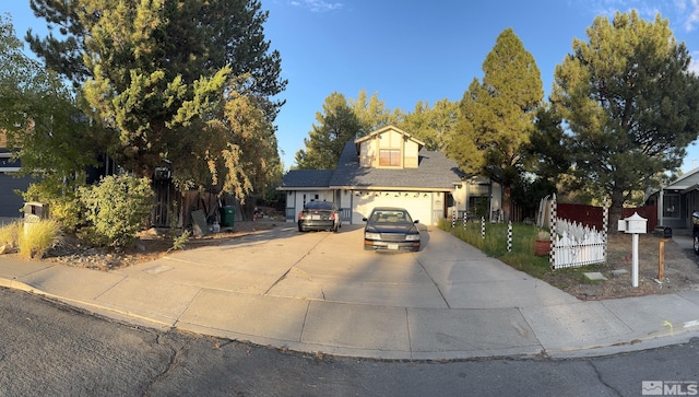 view of front of house with fence and concrete driveway