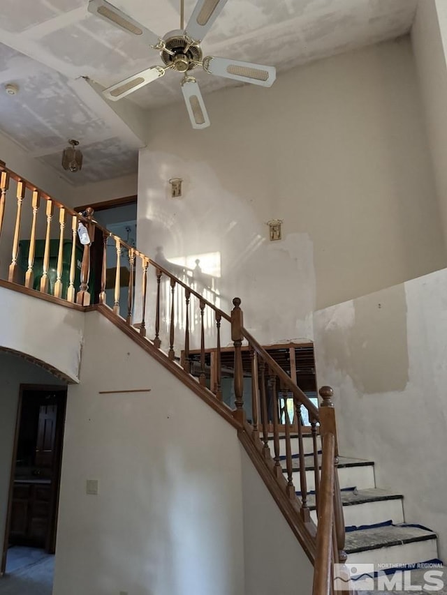 stairway featuring ceiling fan