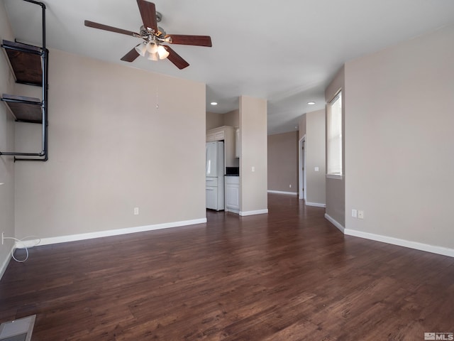 unfurnished living room featuring dark hardwood / wood-style flooring and ceiling fan