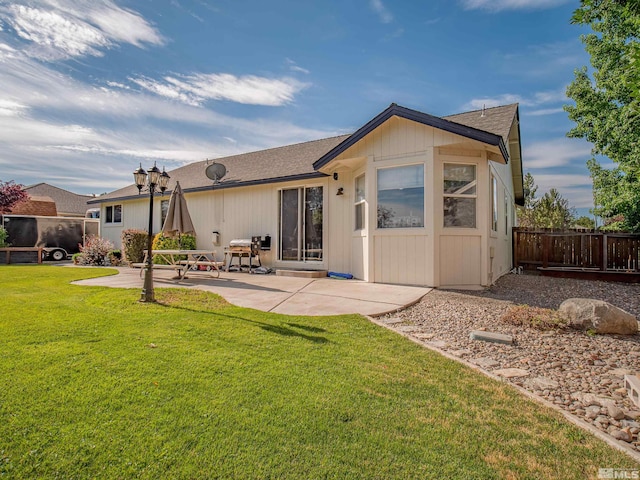 rear view of property featuring a lawn and a patio area