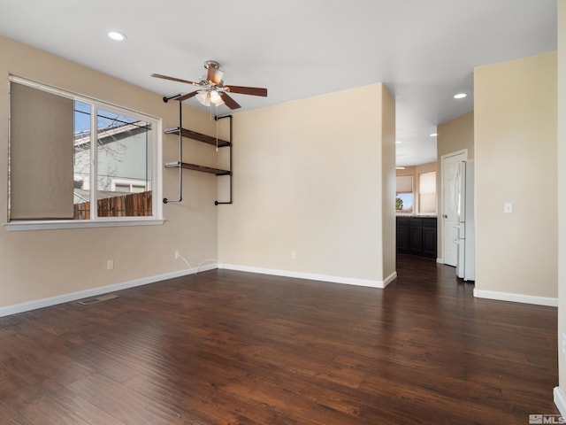 empty room with dark wood-type flooring and ceiling fan