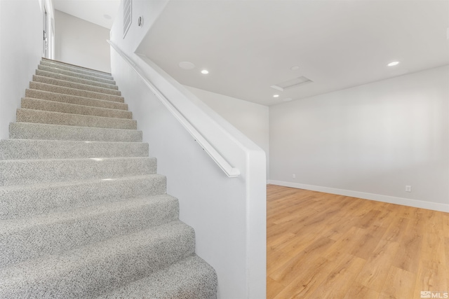 staircase featuring attic access, baseboards, wood finished floors, and recessed lighting