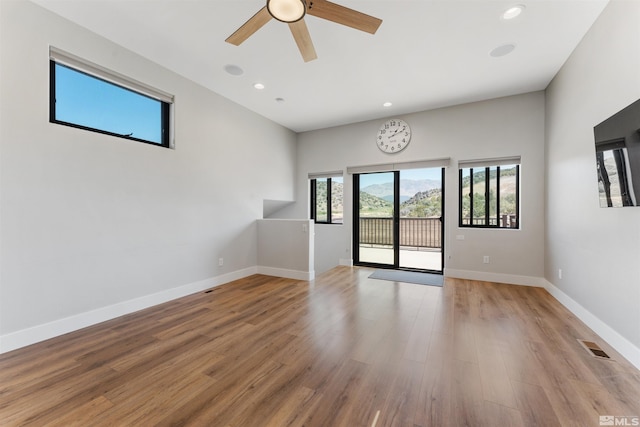 spare room with baseboards, visible vents, a ceiling fan, and light wood finished floors