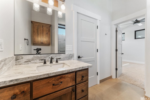 bathroom featuring baseboards, a ceiling fan, and vanity