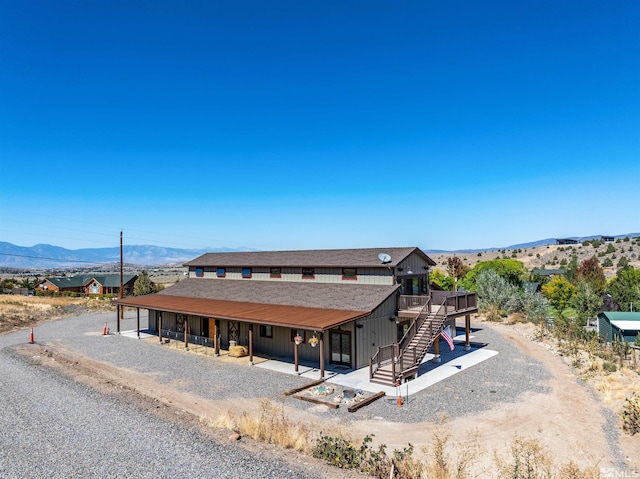 view of front of property with stairs, a patio, and a mountain view