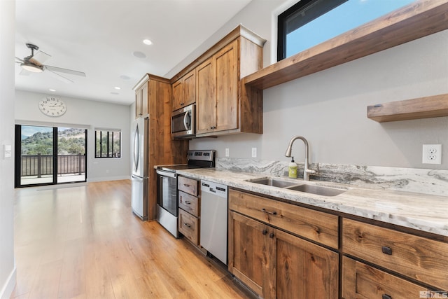 kitchen featuring a sink, open shelves, appliances with stainless steel finishes, brown cabinets, and ceiling fan