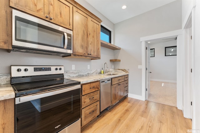 kitchen featuring a sink, stainless steel appliances, brown cabinetry, and open shelves