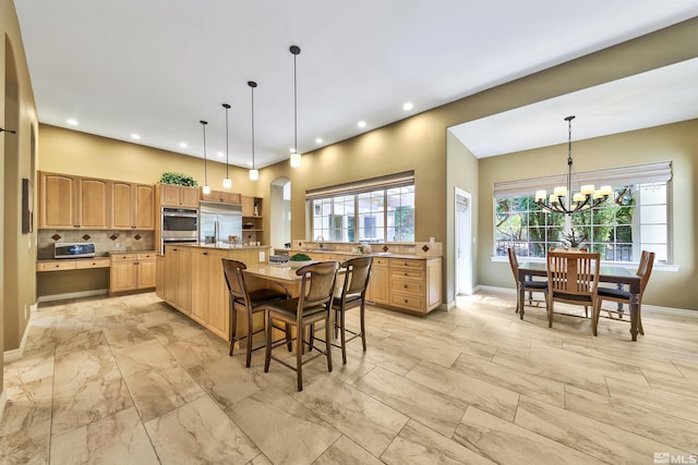 kitchen with oven, a kitchen island, an inviting chandelier, and pendant lighting