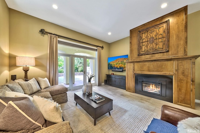 living room with french doors, a fireplace, and light hardwood / wood-style floors