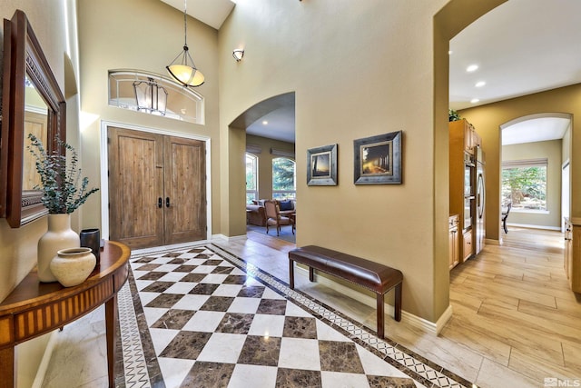 foyer entrance featuring light wood-type flooring and a high ceiling