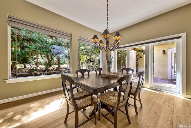 dining area with light hardwood / wood-style flooring and a notable chandelier