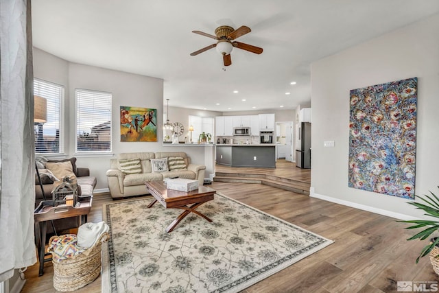 living room featuring ceiling fan and hardwood / wood-style flooring