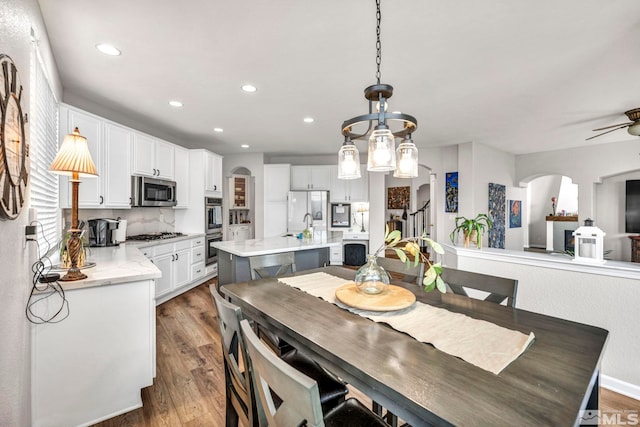 dining space with ceiling fan and dark hardwood / wood-style flooring