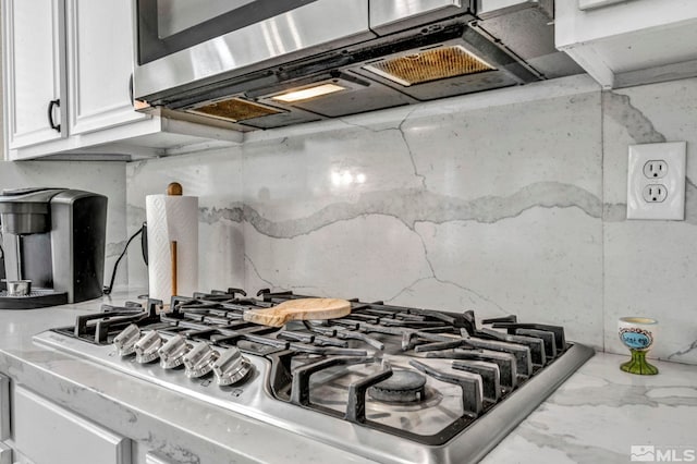 kitchen with white cabinets, stainless steel appliances, and light stone counters