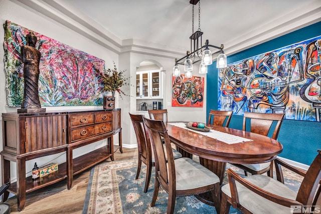 dining area with light hardwood / wood-style flooring and a chandelier