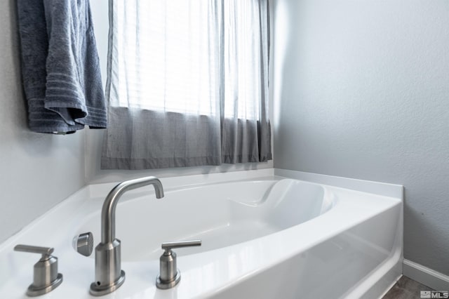 bathroom featuring a tub to relax in and sink