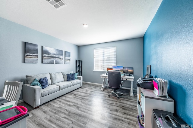 home office with light hardwood / wood-style flooring